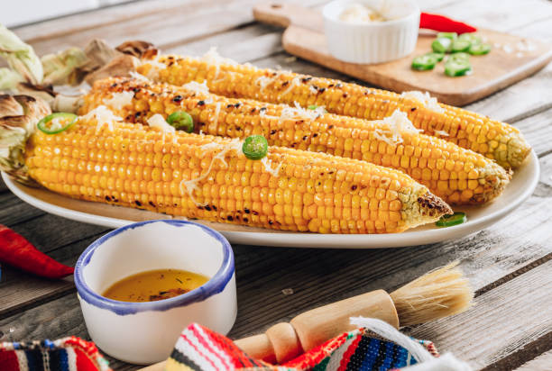 istock Grilled spicy corn cobs on white plate on rustic wooden background 1266836261