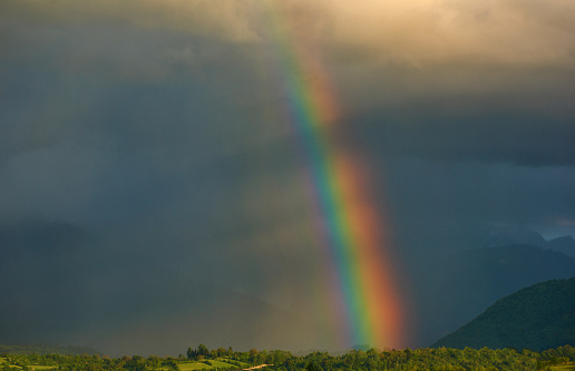Horizontal shot and color image of rainbow after storm in Romania in rural landscape
