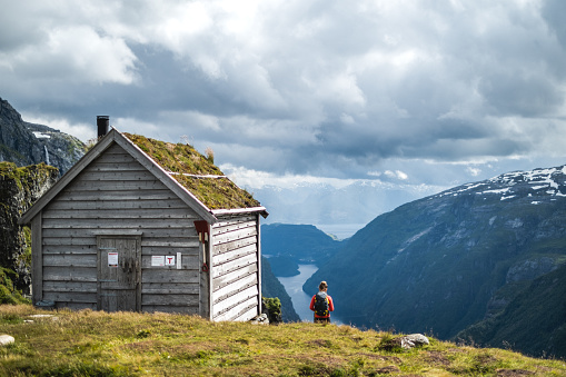 Woman by Kiellandbu in front of Hardanger fjord in Norway.