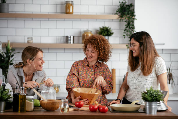 istock Girlfriends having fun in kitchen. Sisters cooking together.. 1266839594