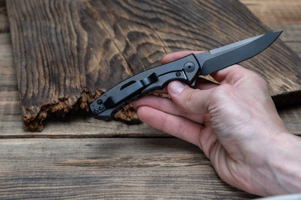 istock Small folding knife in hand. The blade and knife handle are black. 1266839688