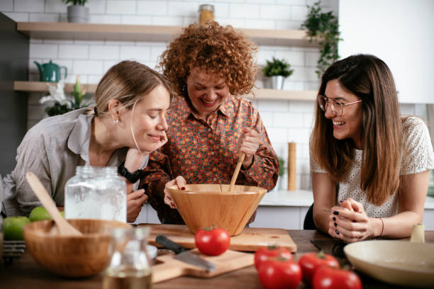 istock Girlfriends having fun in kitchen. Sisters cooking together.. 1266840374