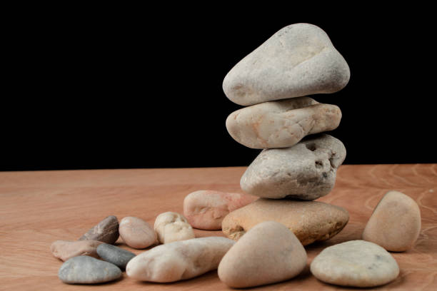 istock a bunch of smooth stones on a board on a black background 1266840571
