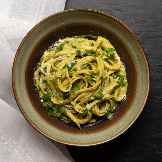 istock Creamy green pasta with poblano pepper and parmesan cheese on dark background 1266841606