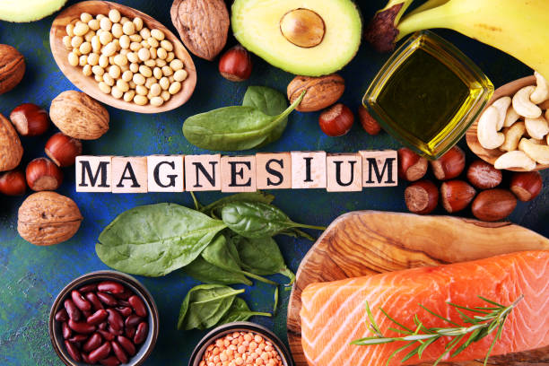 Products containing magnesium: bananas, almonds, avocado, nuts and spinach and eggs on background