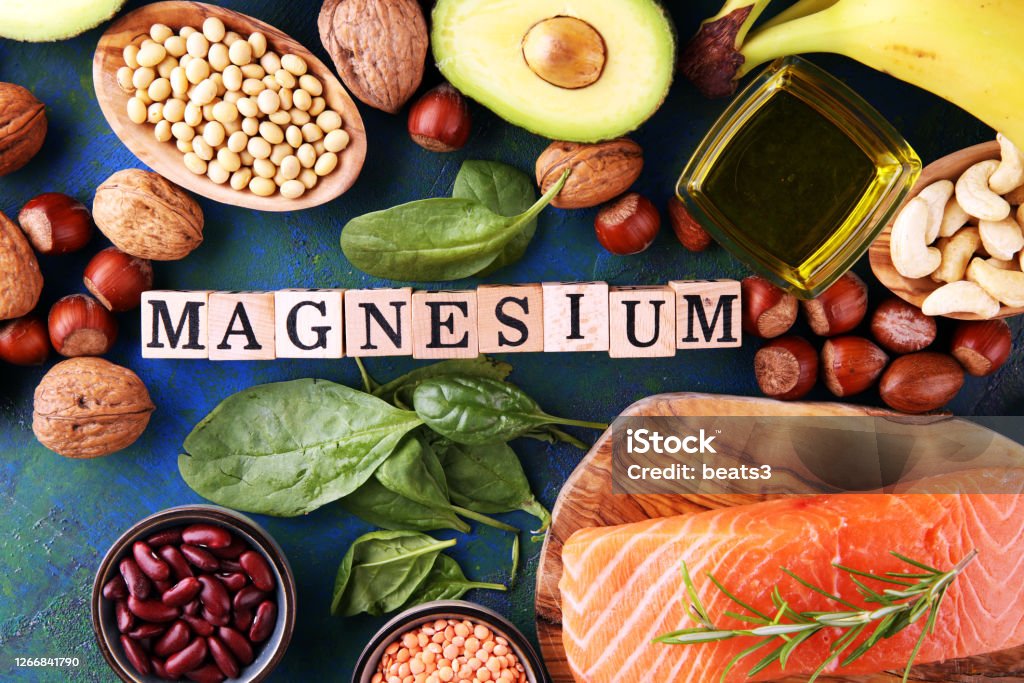 Products containing magnesium: bananas, almonds, avocado, nuts and spinach and eggs on background Products containing magnesium: bananas, almonds, avocado, nuts and spinach and eggs on table Magnesium Stock Photo