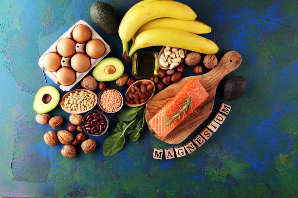 istock Products containing magnesium: bananas, almonds, avocado, nuts and spinach and eggs on background 1266842141