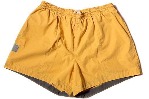 mens yellow swimming trunks on a white background