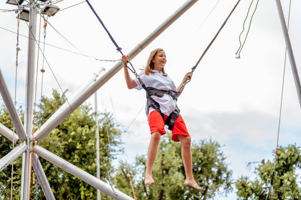 istock Young girl bungee jumping on a trampoline 1266843793