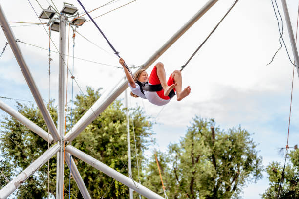 istock Young girl bungee jumping on a trampoline 1266843797