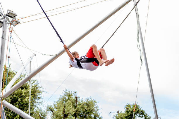 istock Young girl bungee jumping on a trampoline 1266843806