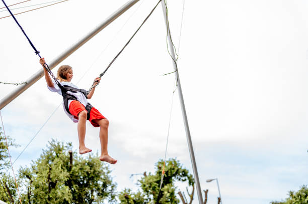istock Young girl bungee jumping on a trampoline 1266843819