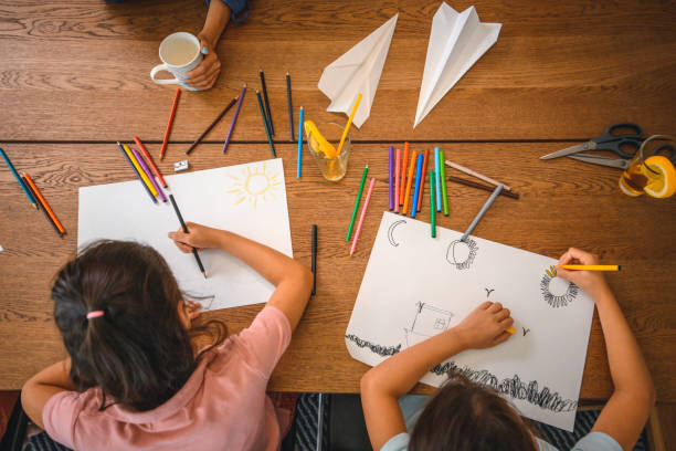 istock Asian Sisters Drawing with Coloured Pencils at Home 1266845675