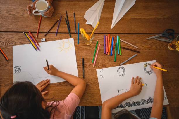 istock Asian Sisters Drawing with Coloured Pencils at Home 1266845693