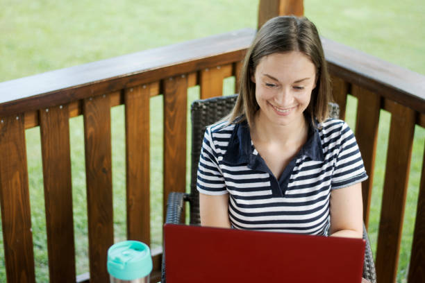 istock Smiling young woman using her laptop 1266847771