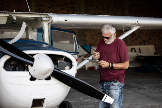 istock Senior man pilot checking ultralight airplane before flight 1266849255