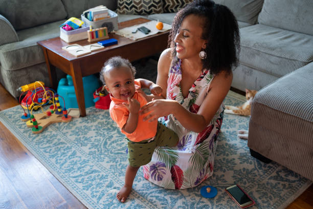 istock Black mom playing with her son in the living room 1266851365