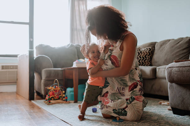 istock Black mom playing with her son in the living room 1266851367