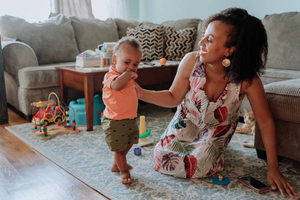 istock Black mom playing with her son in the living room 1266851373
