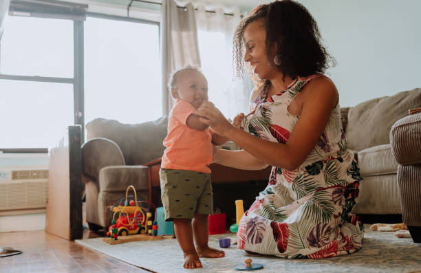 istock Black mom playing with her son in the living room 1266851377