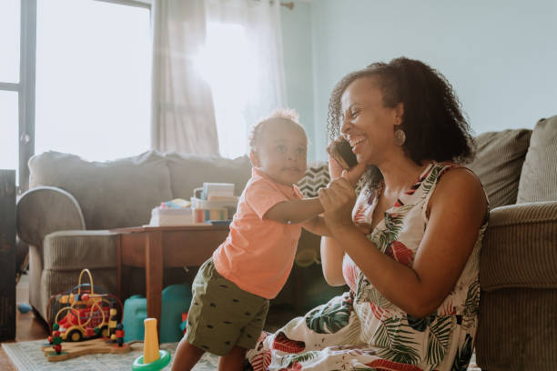 istock Mom playing with her kid while talks on the cell phone 1266851394