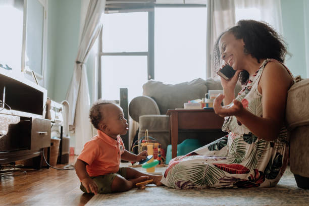 istock Mom playing with her kid while talks on the cell phone 1266851401