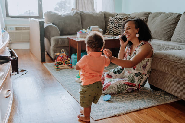 istock Mom playing with her kid while talks on the cell phone 1266851430