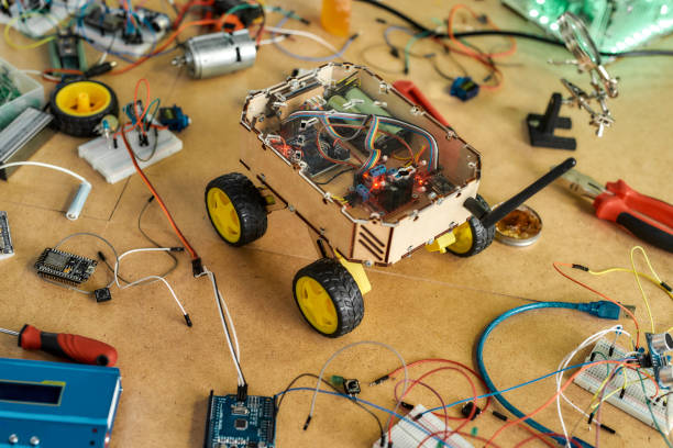 Robot diy assembly kit. Electrical components kit for building digital devices. Robotics parts and elements lying on a wooden desk. Electronics module set