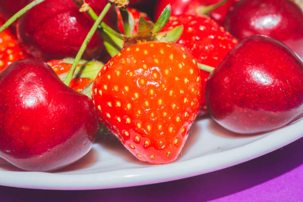 Strawberries and cherries on the white plate