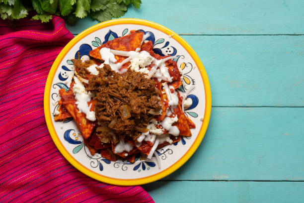 istock Mexican red chilaquiles with chilorio and cheese on turquoise background 1266855985