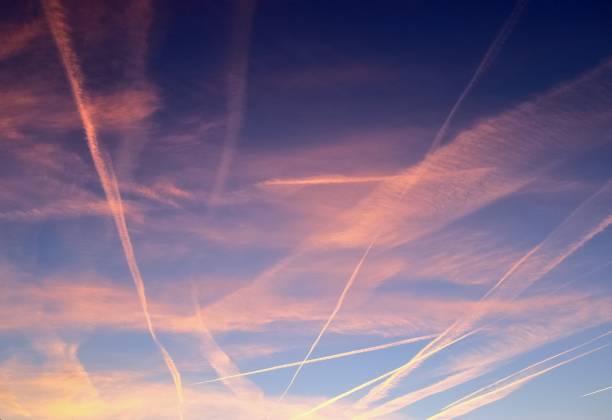 la condensa degli aerei si contrae nel cielo blu tra alcune nuvole - vapor trail cirrus sky cloudscape foto e immagini stock