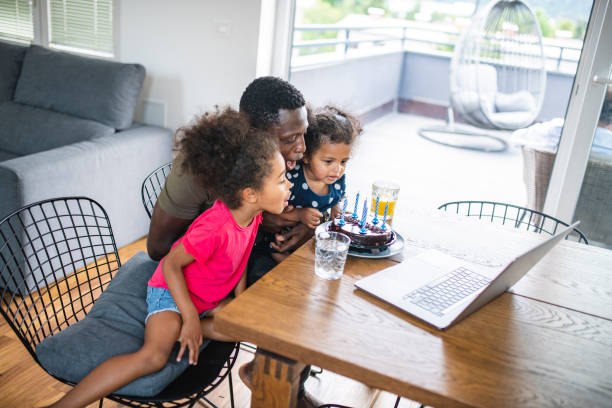 istock Father with two daughters using laptop to make video call 1266857170
