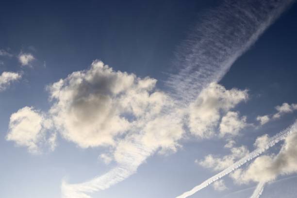 istock Aircraft condensation contrails in the blue sky inbetween some clouds 1266857188