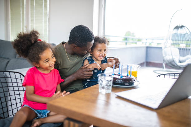 istock Father with two daughters using laptop to make video call 1266857955