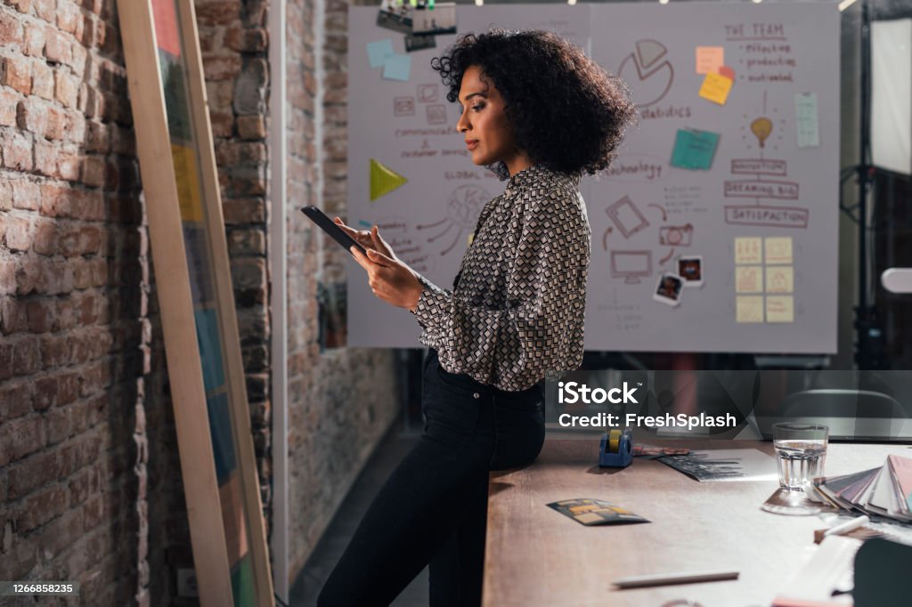 Young Designer Using a Digital Tablet at the Studio Women in business: a young designer using technology at the office, startups concept. Mood Board Stock Photo