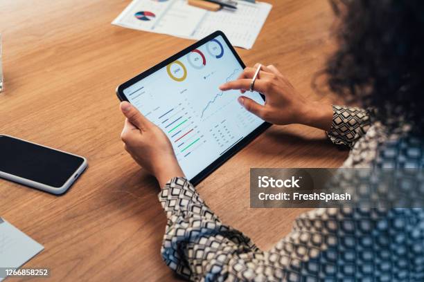 Anonymous Businesswoman Analyzing Statistical Business Reports On Her Tablet Pc At The Office A Close Up Stock Photo - Download Image Now