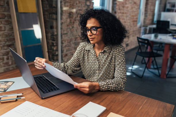 istock Young Businesswoman Reading Documents at the Office 1266858271