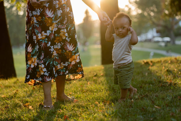 istock Black child learning to walk and his mother supporting him 1266863635