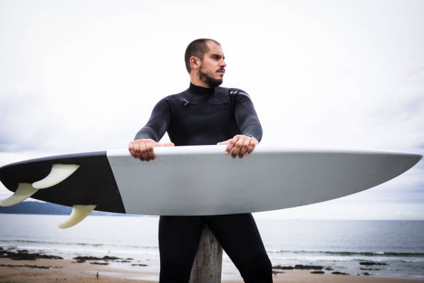 istock Surfboard Surfer, Man With Wetsuit on the Beach 1266865890