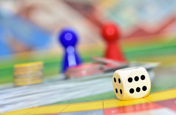 istock Dice and red and blue figures in background on the board. 1266868426