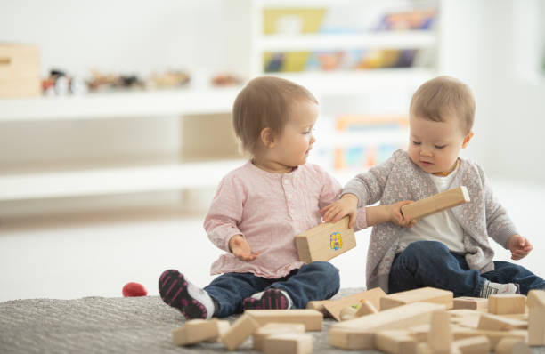 istock Baby sisters playing together 1266869275