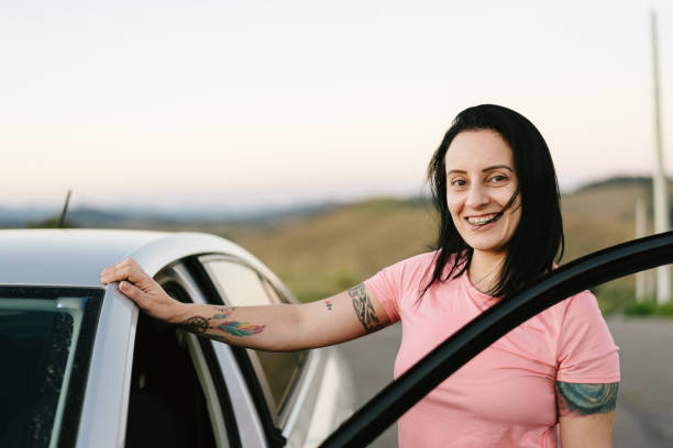 istock Smiling woman getting in the car 1266871538