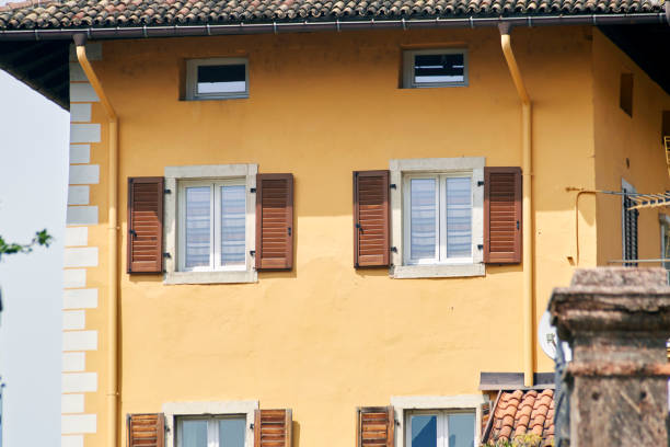 istock Italian windows on the yellow wall facade with open brown color classic shutters 1266871677