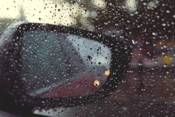 istock Rear view mirror seen through rain drops on the car window. 1266872591