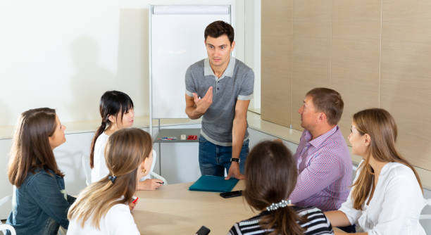 istock Man reading out report to colleagues 1266872696