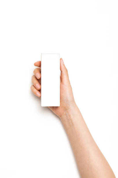 istock woman hand hold a cosmetic container on the white background. 1266873743