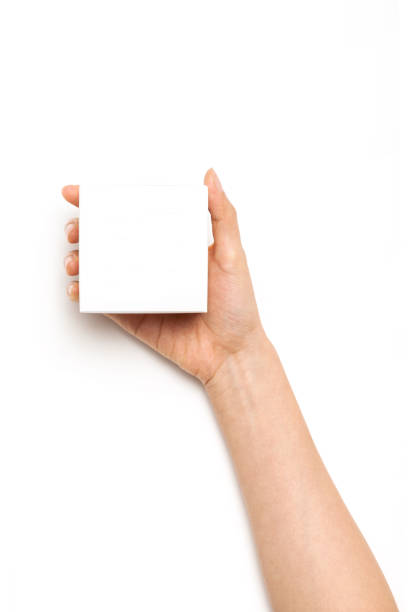 istock woman hand hold a cosmetic container box on the white background. 1266873755