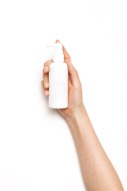 istock woman hand hold a cosmetic container spray on the white background. 1266873765