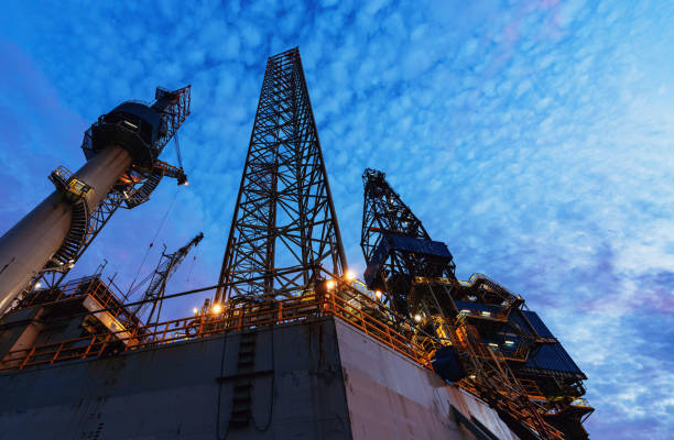 Jackup Offshore Oil Rig A jackup offshore oil drilling rig is docked at port for maintenance & repairs prior to reassignment. drilling rig stock pictures, royalty-free photos & images