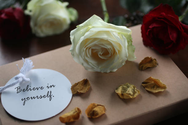 istock Note to self concept with roses, dried petals and text message on tag white paper label - Believe in yourself. 1266883591